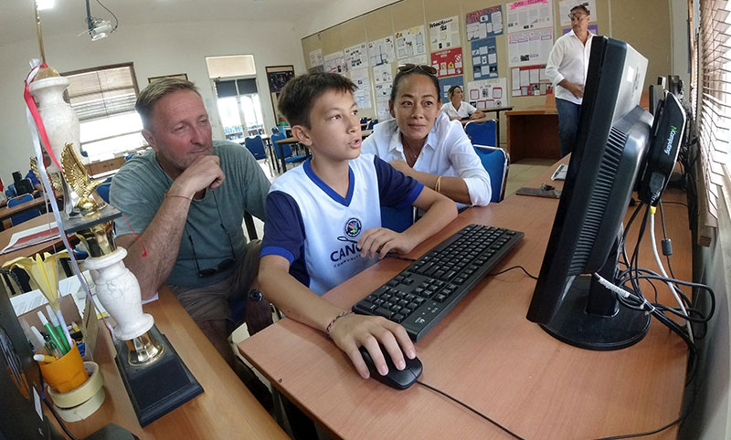 Senior School teacher helping pupil with the computer